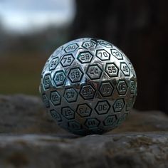 a metal ball sitting on top of a rock