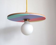 a multicolored light fixture hanging from a ceiling with a white ball on it