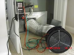 a blow dryer sitting on the floor in front of a wall with wires attached to it