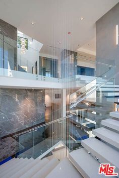 an image of stairs in a house with glass railings on the bottom and second floor