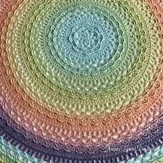 a multicolored crocheted doily is shown