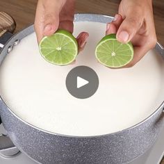 two hands holding limes on top of a frying pan