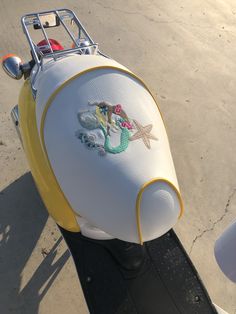 a scooter is decorated with an image of a mermaid and starfish on it