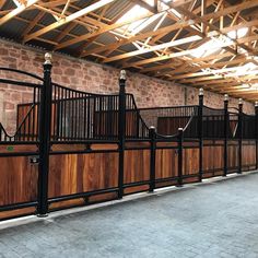 a row of wooden fences in front of a brick wall and ceiling with exposed beams