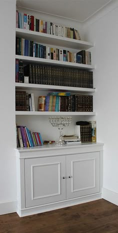 a bookshelf filled with lots of books in a room