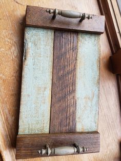 a piece of wood that is sitting on top of a wooden table and has two handles