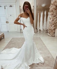 a woman is taking a selfie in her wedding dress while looking into the mirror