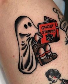 a person with a ghost tattoo holding a book