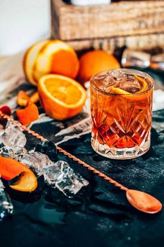 an old fashioned cocktail with oranges and ice