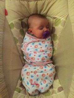 a baby laying in a crib with a pacifier in it's mouth