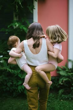 a woman holding two small children in her arms