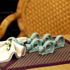 there are several pieces of blue pottery on the table with napkins and flowers in it