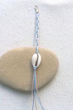 a rock with some blue and white string attached to it, on top of sand