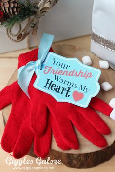 a pair of red gloves sitting on top of a wooden table next to a christmas tree