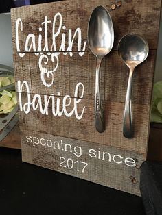 two spoons are attached to a wooden sign