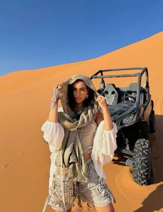 a woman standing in the desert with her hands on her head