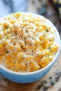 a blue bowl filled with corn and cheese