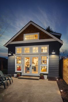 a house that is lit up at night with lights on the front and side windows