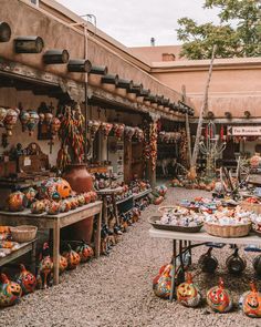 an outdoor market with pumpkins and other items