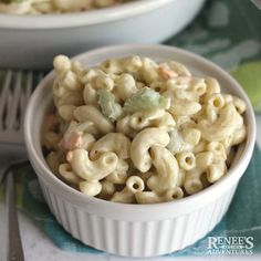 two bowls filled with macaroni and cheese on top of a green table cloth