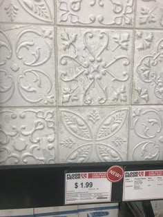 some white tiles are on the wall in a store display case for $ 1 99 per square foot