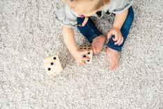 a toddler playing with wooden blocks on the floor