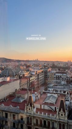 the sun is setting over some buildings in barcelona, spain on a clear day with no clouds