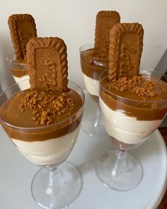 three desserts in small glasses on a table