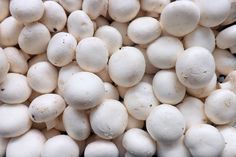 white mushrooms are piled up in a pile