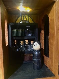 a wooden shelf filled with books and miniature figurines on top of it's sides