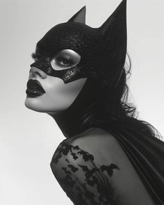 a woman wearing a cat mask and black dress