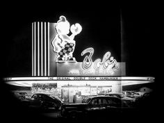 an old movie theater with cars parked in front