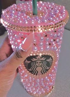 a person holding up a pink starbucks drink