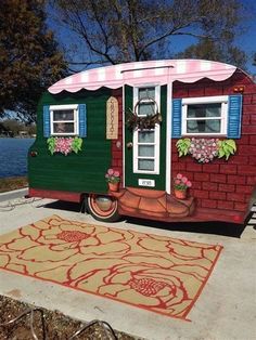 a colorful trailer is parked next to the water