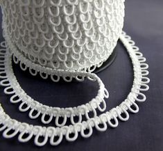 a spool of white thread sitting on top of a table next to a roll of string