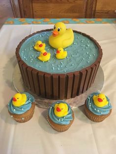 there is a cake and cupcakes on the table with rubber ducks in it