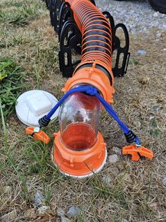 an orange and blue fire hydrant sitting on the ground next to some trash cans