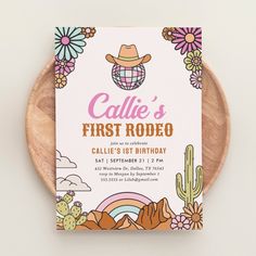 the first rodeo birthday party card is displayed on a wooden plate with cactus and flowers