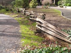 an old wooden fence sitting on the side of a road