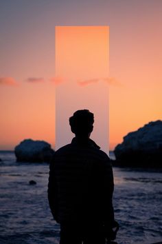 a man standing on top of a beach next to the ocean