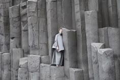 a woman standing in between two large rocks