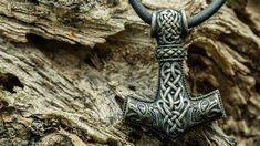 an old metal cross is hanging on a piece of driftwood that has been carved into it