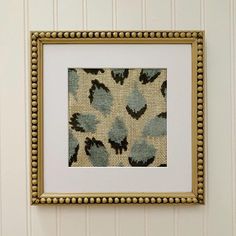 an image of a painting on the wall in a frame with bead trim around it