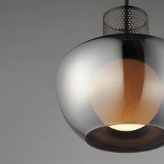 a glass light hanging from the ceiling in a room with gray walls and flooring