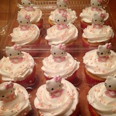 cupcakes with hello kitty decorations on them are in a plastic tray, ready to be eaten