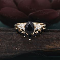 a black and white diamond ring sitting on top of a piece of wood