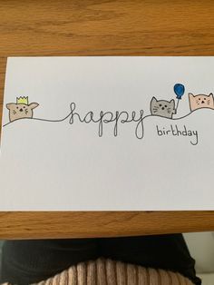 someone holding up a birthday card with cats on it