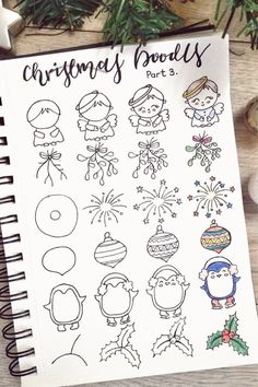 a notebook with christmas doodles on it next to some ornaments and other things in the background