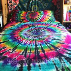 a bed covered in a colorful tie dyed comforter