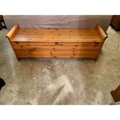 a wooden bench sitting on top of a cement floor